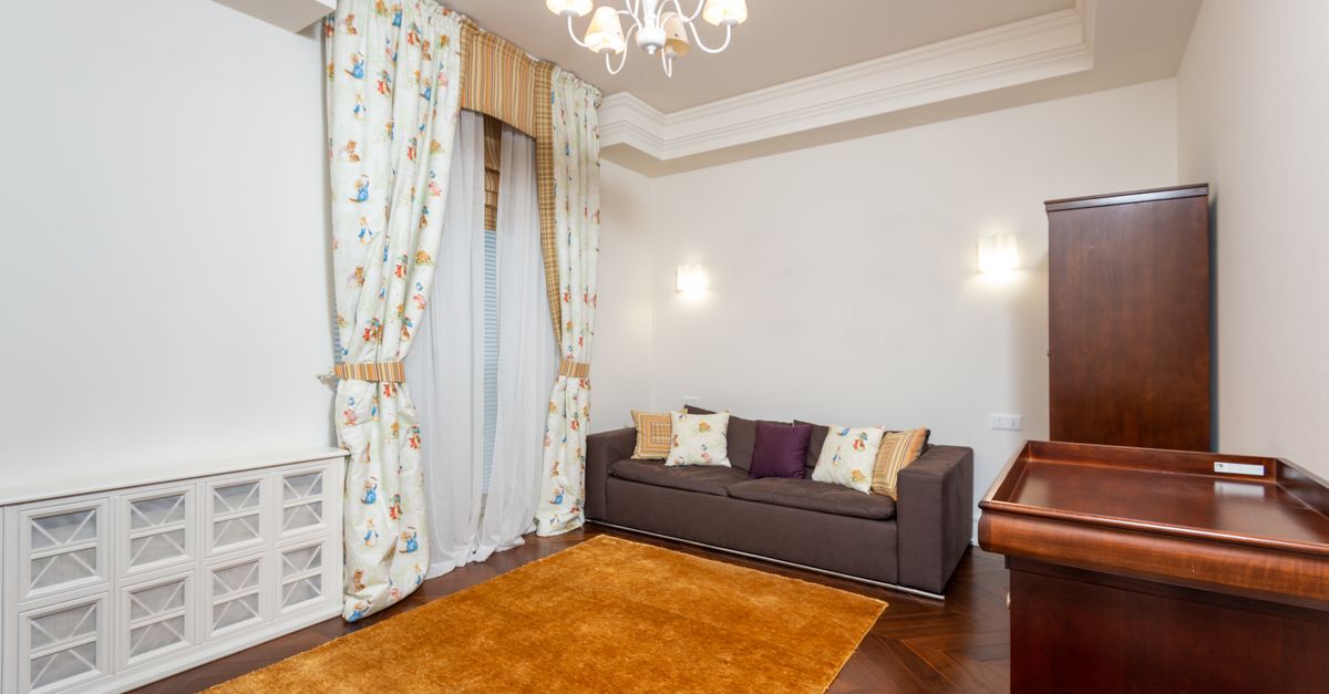 Bright and spacious living room featuring elegant chandelier, cozy sofa, and tasteful decor for a stylish ambiance.